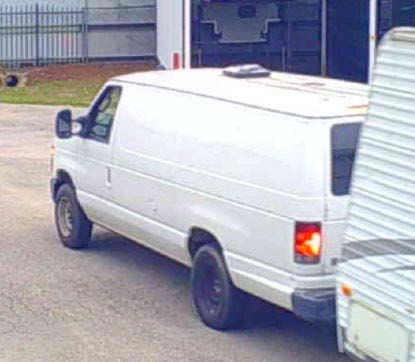 Camera footage photo of a white, windowless, unmarked van pulling stolen trailer. 